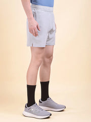 Person wearing light gray shorts (DCYPHR Men's Mono Flex Short-Light Grey) and black socks and sports shoes